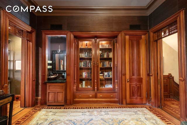 interior space with visible vents, light wood-style floors, and crown molding