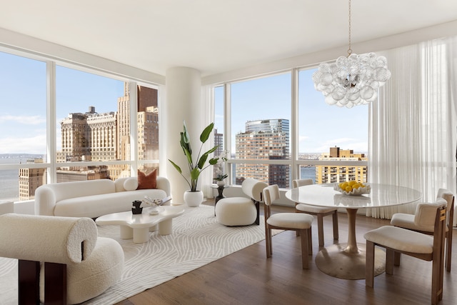 sunroom featuring a city view, plenty of natural light, and a notable chandelier