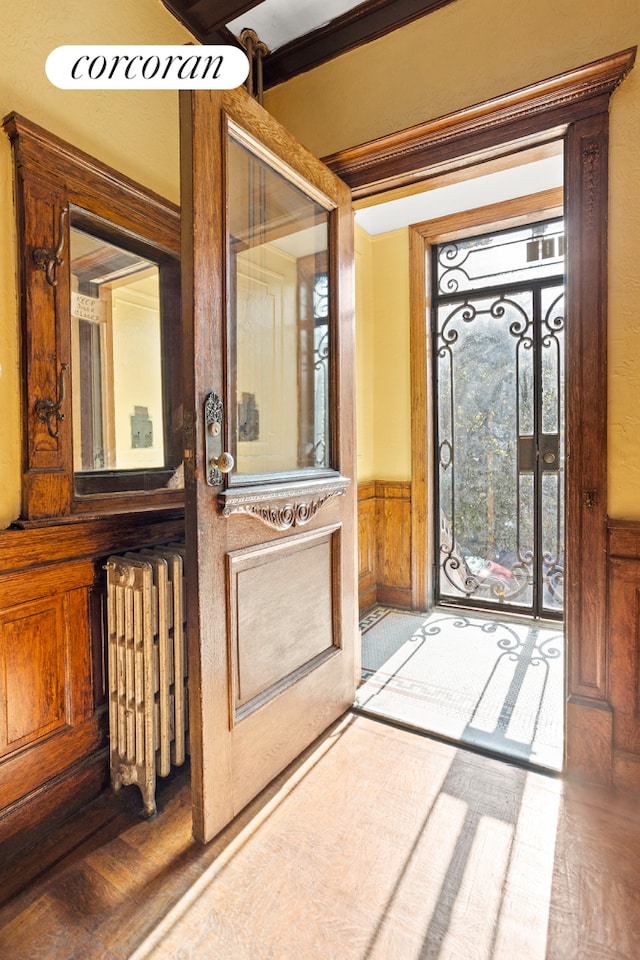 doorway featuring a wainscoted wall and radiator heating unit