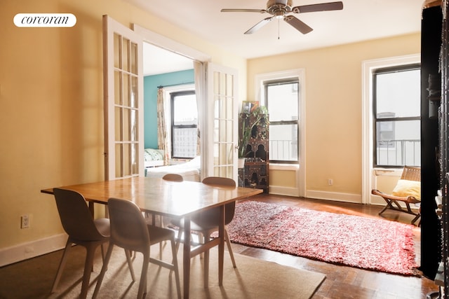 dining area with ceiling fan, baseboards, and wood finished floors