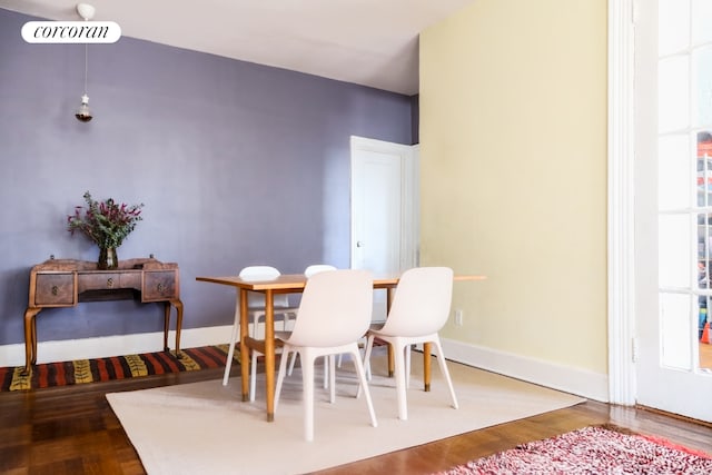dining area with wood finished floors, plenty of natural light, and baseboards