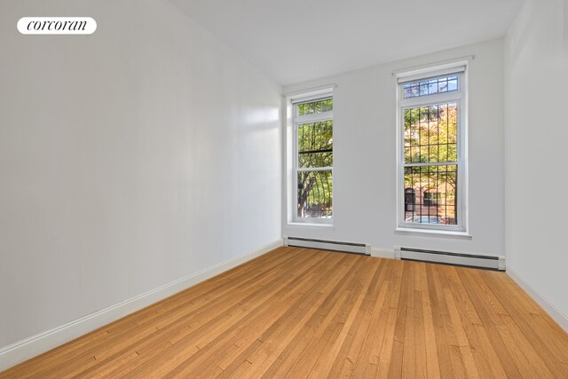 home office with light wood-type flooring and a baseboard radiator