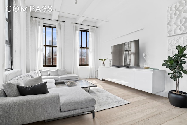 448 W 37th St Unit 8C, New York City, NY 10018 - living room with wood finished floors and beamed ceiling