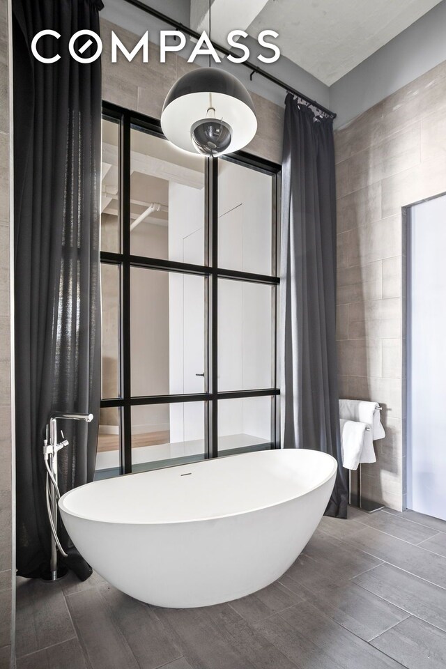 bathroom featuring tile walls and a washtub