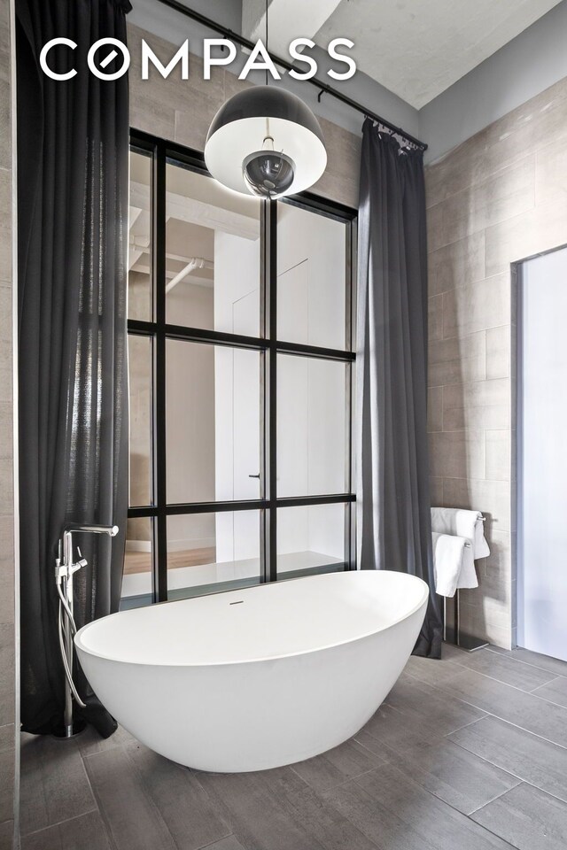 448 W 37th St Unit 8C, New York City, NY 10018 - full bath with a soaking tub and tile walls
