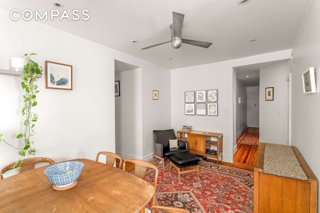 dining room featuring ceiling fan, baseboards, and wood finished floors