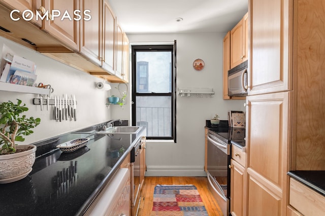 501 W 122nd St Unit A2, New York City, NY 10027 - kitchen featuring stainless steel appliances, light wood finished floors, dark countertops, and light brown cabinets