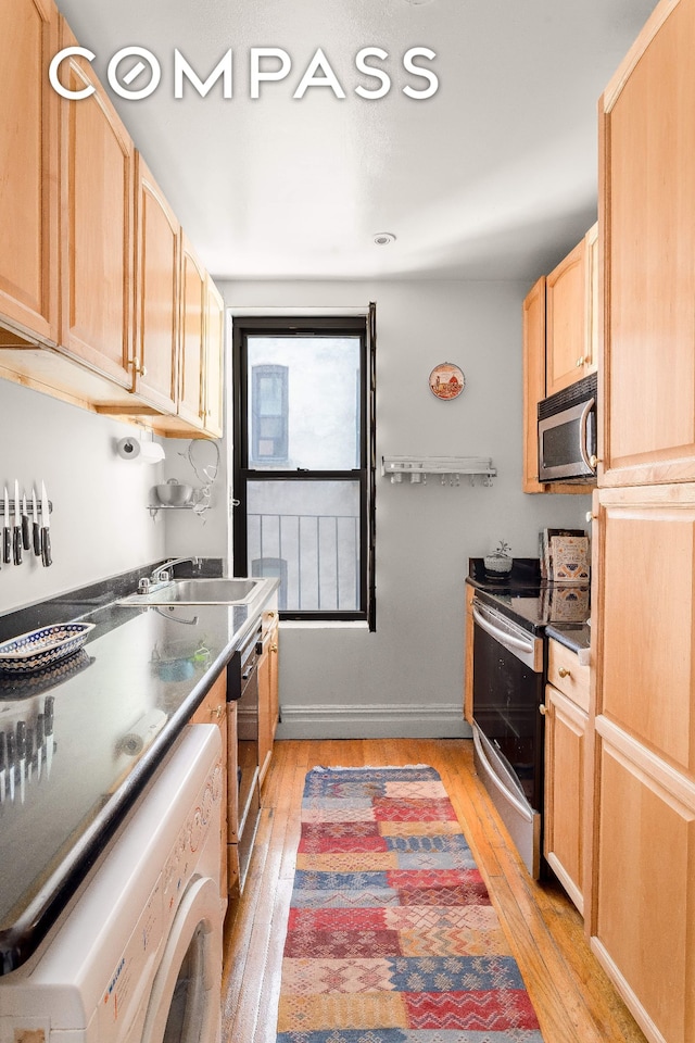 501 W 122nd St Unit A2, New York City, NY 10027 - kitchen featuring appliances with stainless steel finishes, washer / dryer, light brown cabinetry, light wood-style floors, and dark countertops
