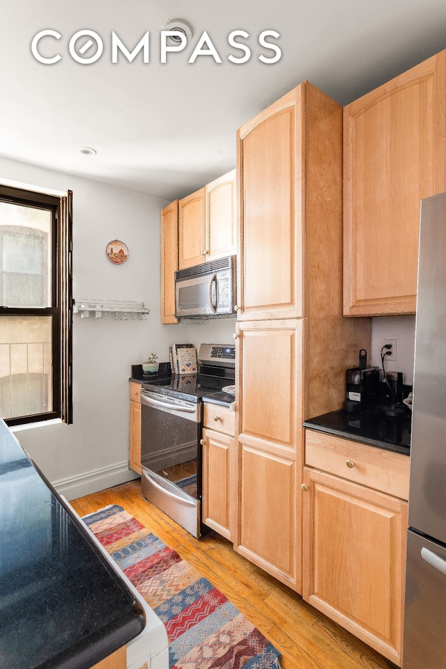 501 W 122nd St Unit A2, New York City, NY 10027 - kitchen with stainless steel appliances, light brown cabinets, light wood-type flooring, and dark countertops