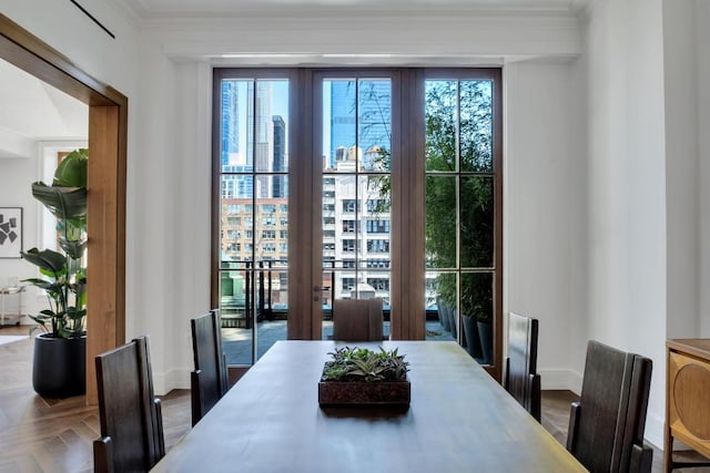 dining space featuring ornamental molding, parquet flooring, and a healthy amount of sunlight