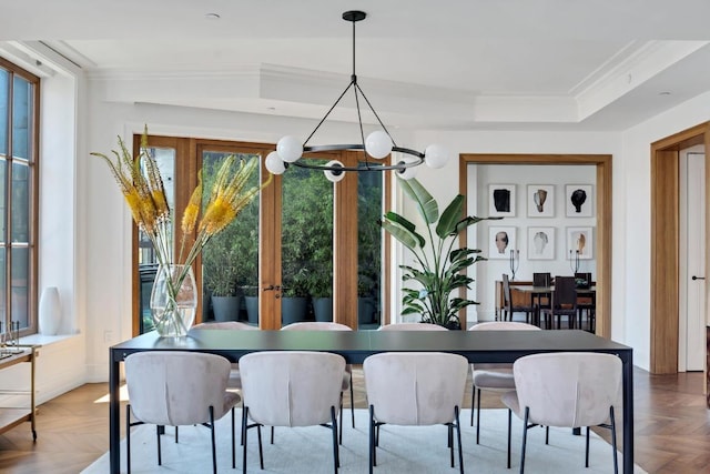 dining room with parquet floors, crown molding, a notable chandelier, and a healthy amount of sunlight