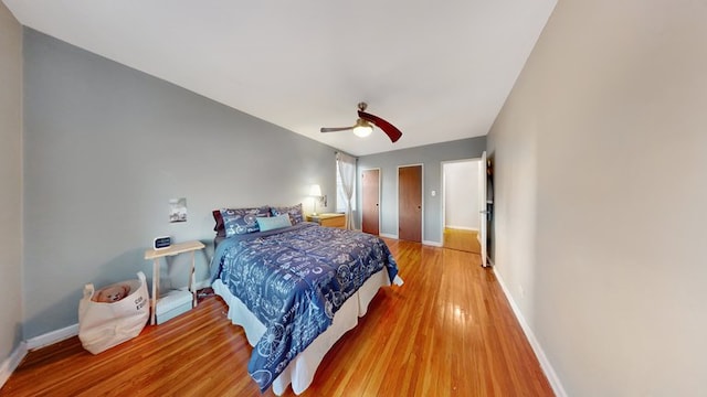 bedroom featuring a ceiling fan, baseboards, and wood finished floors