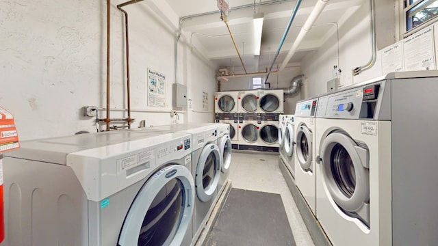 community laundry room featuring a garage, washing machine and dryer, dark floors, and stacked washer / dryer