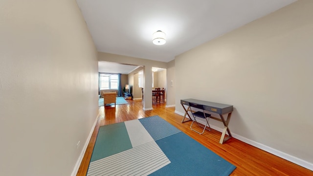 exercise area featuring baseboards and wood finished floors