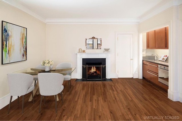 dining space featuring sink, dark hardwood / wood-style flooring, and ornamental molding