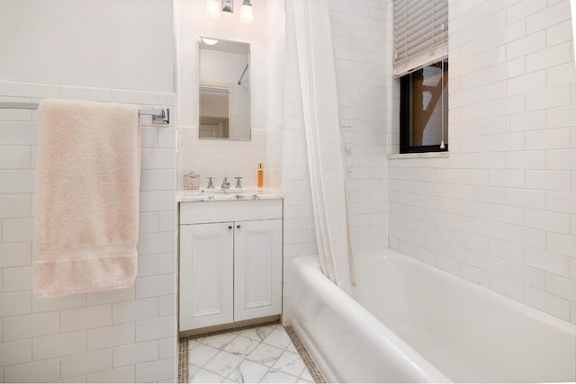 bathroom featuring tile walls, vanity, and shower / bath combo with shower curtain