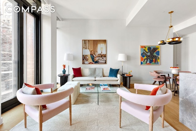 living room with light hardwood / wood-style floors and an inviting chandelier