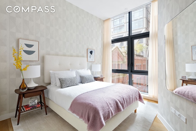 bedroom featuring wallpapered walls and baseboards