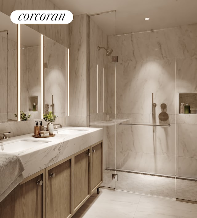 full bathroom featuring double vanity, tile walls, a marble finish shower, and a sink