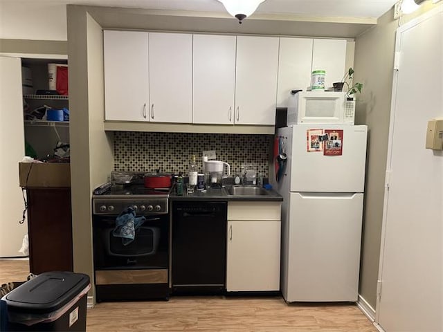 kitchen featuring white appliances, light wood-type flooring, backsplash, and a sink