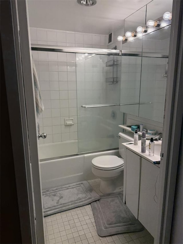 bathroom with tile patterned floors, visible vents, toilet, combined bath / shower with glass door, and vanity