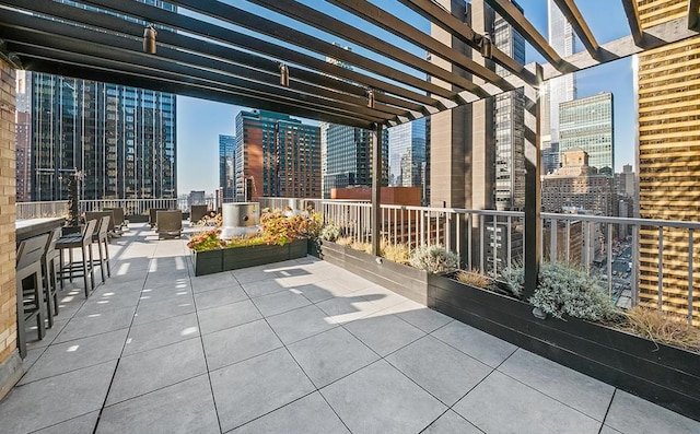 view of patio / terrace featuring a balcony, a view of city, and a pergola