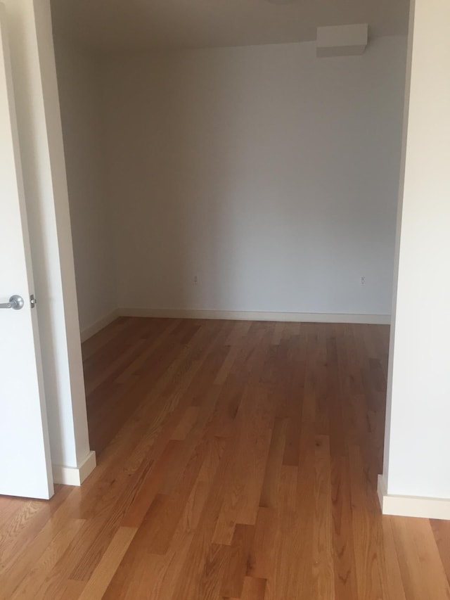 unfurnished room with light wood-type flooring and baseboards