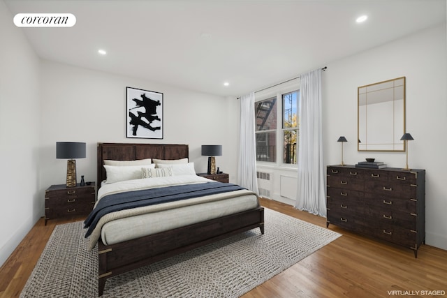 bedroom with wood-type flooring and radiator heating unit