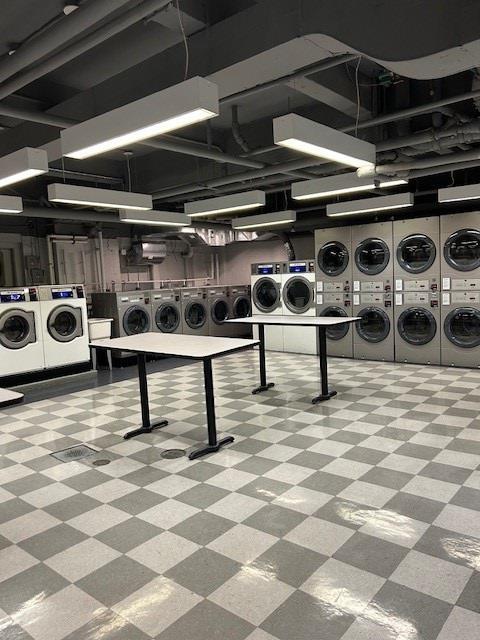 clothes washing area featuring stacked washer / drying machine and washer and clothes dryer