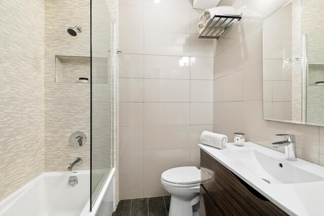 220 Madison Ave Unit 15N, New York City, NY 10016 - bathroom featuring tile walls, shower / bathing tub combination, vanity, and toilet