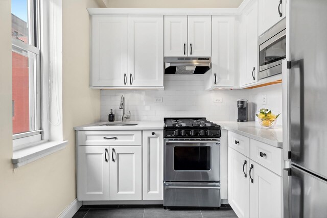 220 Madison Ave Unit 15N, New York City, NY 10016 - kitchen with light countertops, appliances with stainless steel finishes, under cabinet range hood, and a sink