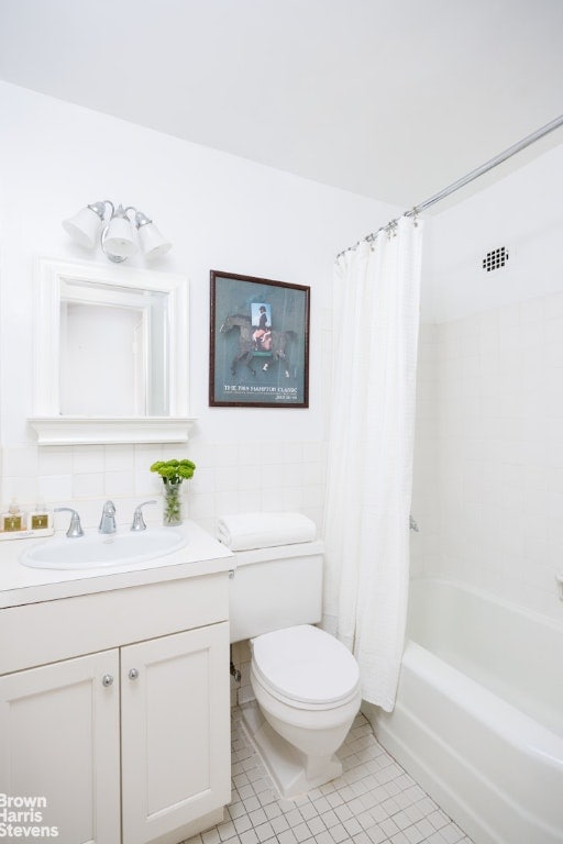 full bathroom featuring toilet, tasteful backsplash, shower / tub combo, tile patterned floors, and tile walls