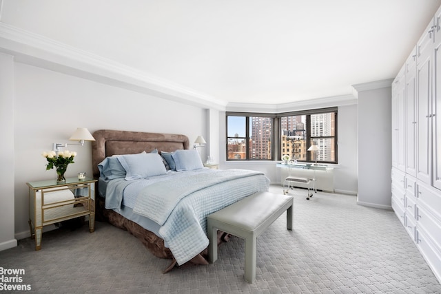 bedroom with ornamental molding and light colored carpet