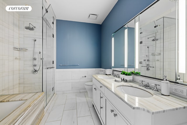 bathroom featuring vanity, tile walls, an enclosed shower, and toilet