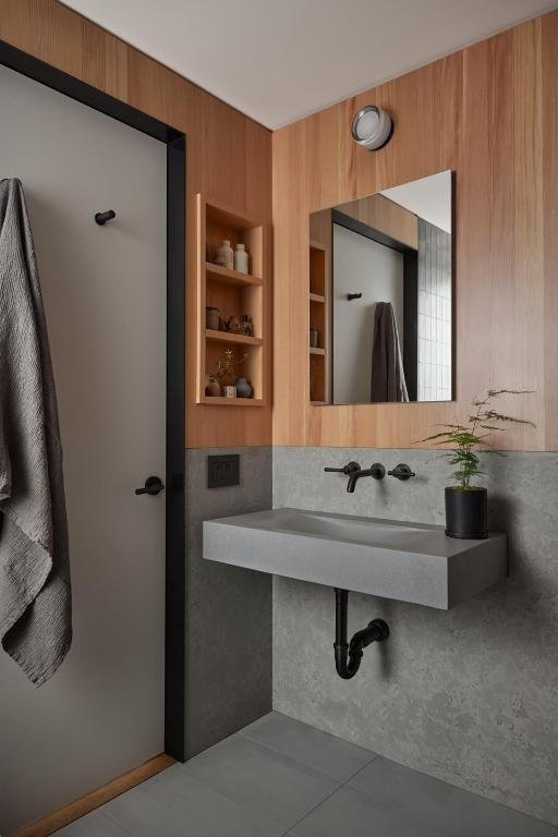 bathroom with wood walls, built in shelves, and a sink