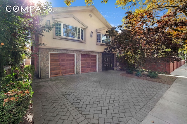 60 82nd St, New York City, NY 11209 - view of front of property with stucco siding, decorative driveway, a garage, and stone siding