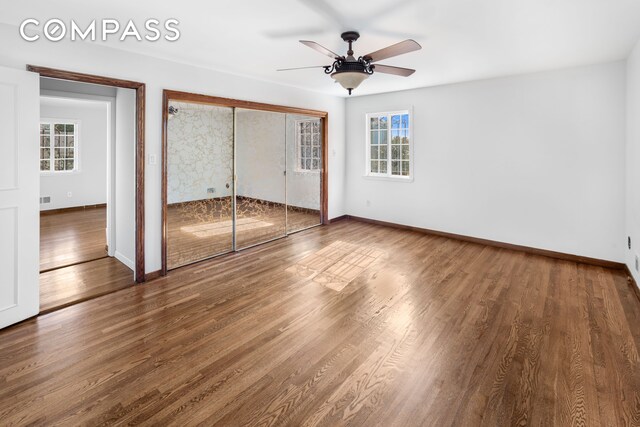 unfurnished bedroom with a closet, visible vents, baseboards, and wood finished floors