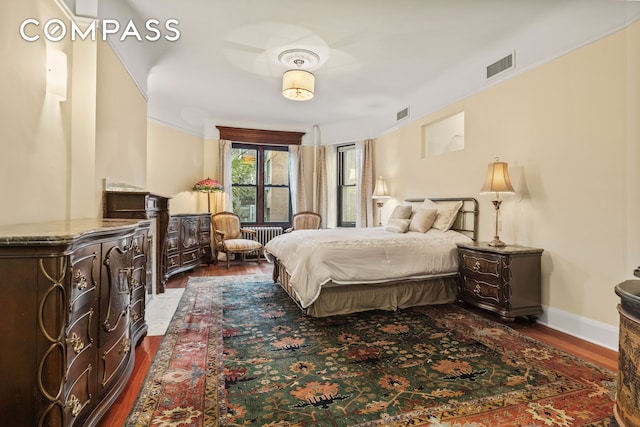 bedroom featuring dark wood-style floors, visible vents, and baseboards