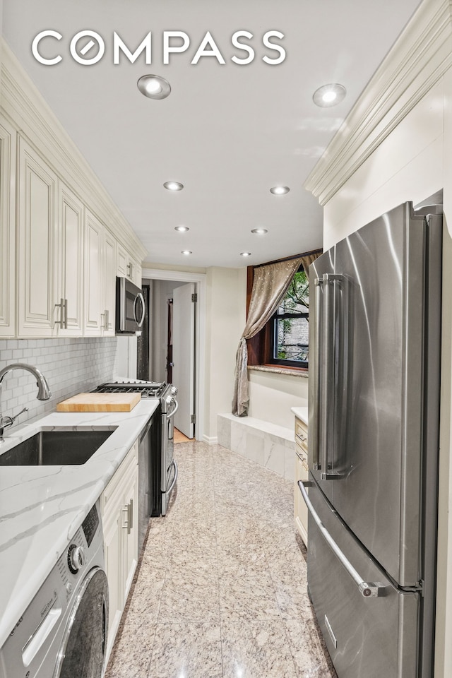 kitchen with washer / dryer, appliances with stainless steel finishes, granite finish floor, a sink, and recessed lighting