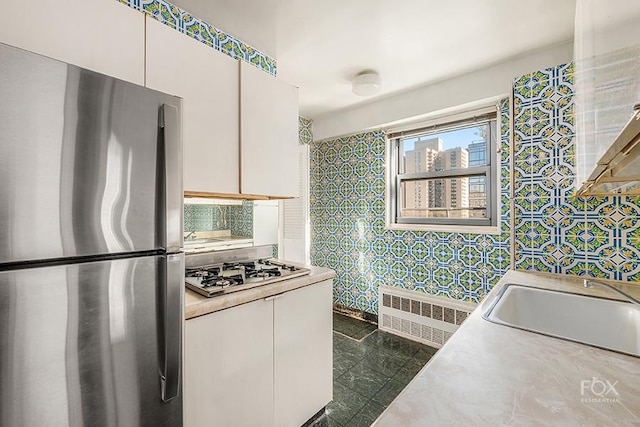 kitchen featuring stainless steel appliances, white cabinets, and sink