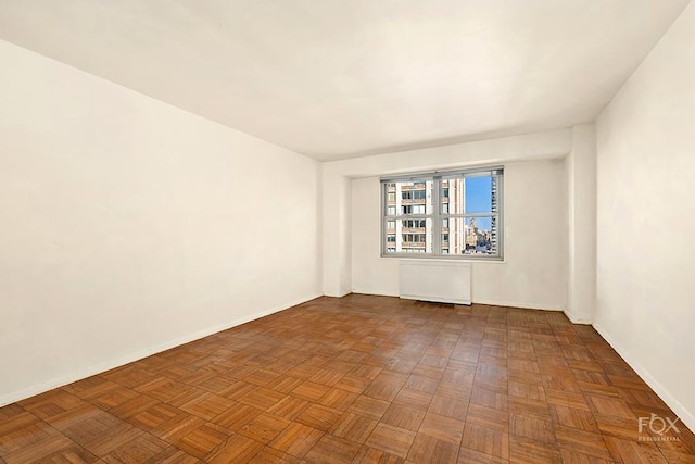 empty room featuring radiator and parquet flooring