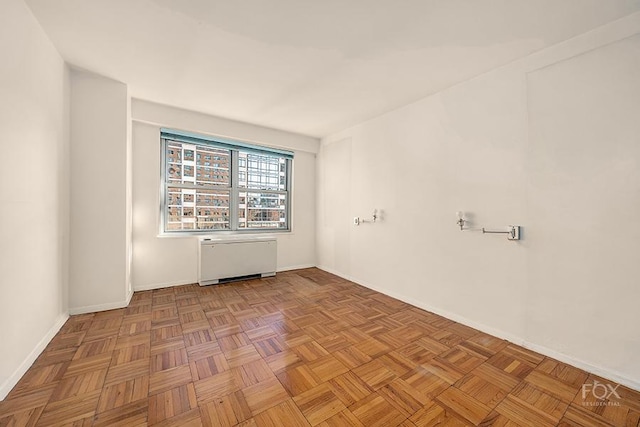 empty room featuring light parquet flooring and radiator