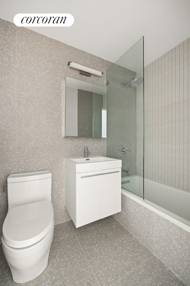55 E 87th St Unit 14E, New York City, NY 10128 - full bath featuring tiled shower / bath combo, vanity, toilet, and tile patterned flooring