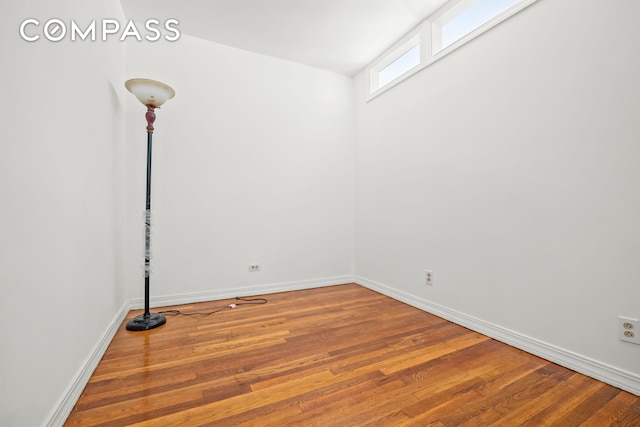 spare room with wood finished floors and baseboards