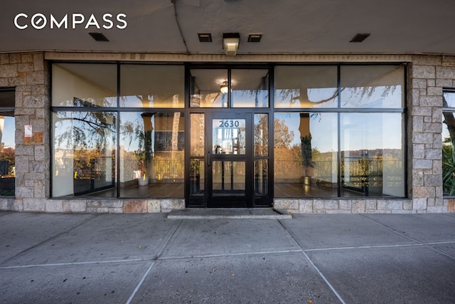 property entrance with stone siding and visible vents