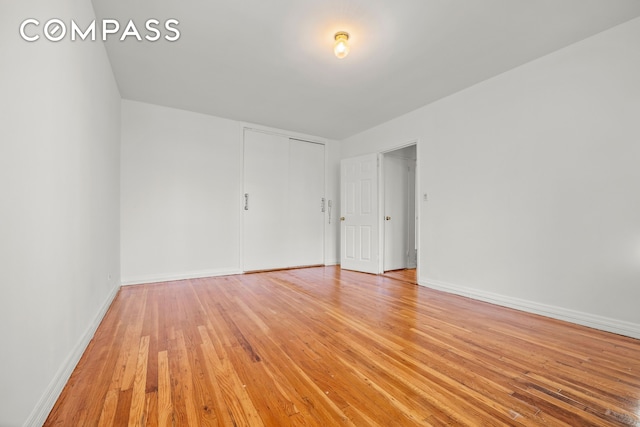 empty room featuring light wood-type flooring and baseboards