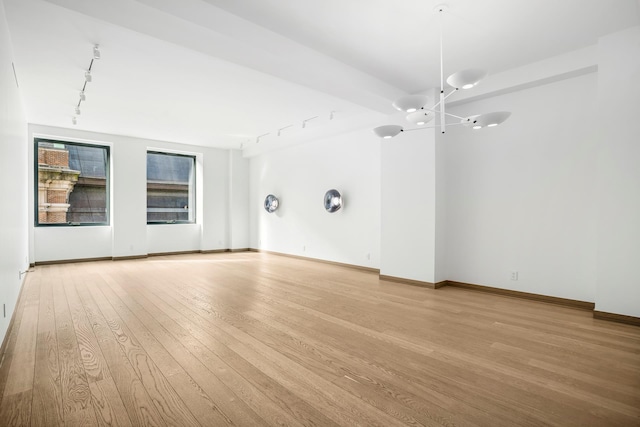 88 Lexington Ave Unit 507, New York City, NY 10016 - unfurnished room featuring rail lighting, a chandelier, and light wood finished floors