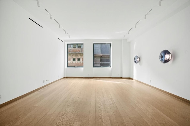 unfurnished room with light wood-type flooring and track lighting