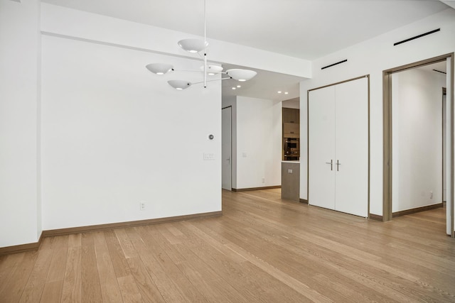 interior space featuring light wood-type flooring and baseboards