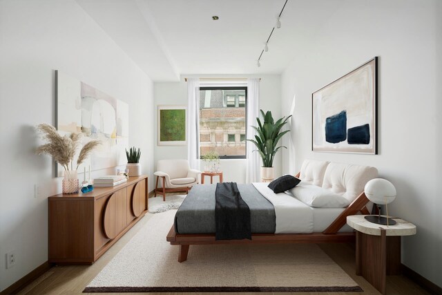 bedroom with light wood-type flooring, rail lighting, and baseboards